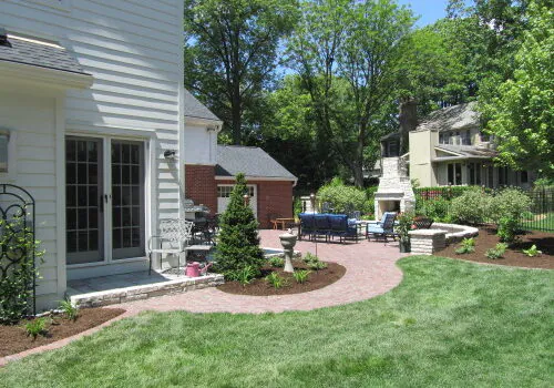 A backyard with a stone path going around the house, part of Landscaping Services for Peoria IL 
