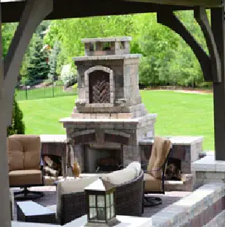 A tall outdoor fireplace with ample seating in front