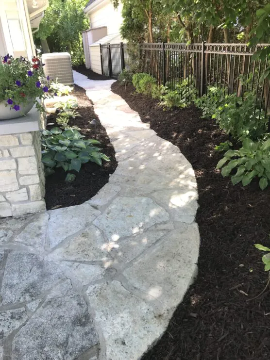 A custom stone walkway through a garden, installed by Mark Hoerr Landscaping in Peoria IL
