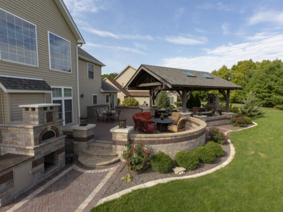 Custom paver patio and stone retaining wall outdoor living space installed by a premier landscaper in Morton IL.